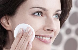 Frau benutzt Gesichtswasser