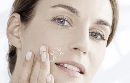 Frau trägt Konzentrat zwischen den Augen auf.