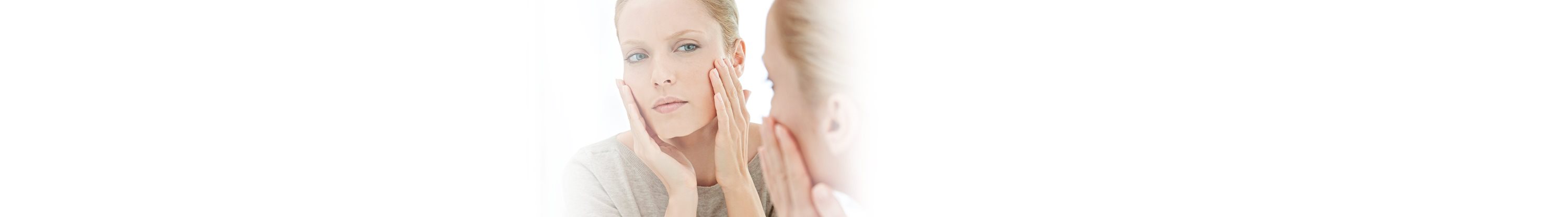 Frau berührt ihr Gesicht.